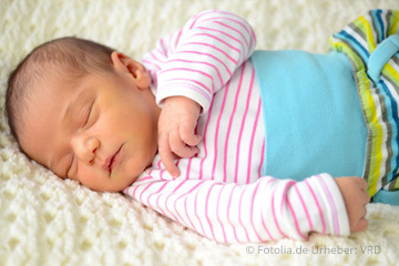 Angebote für »Offene Treffen« – Hier: Eltern-Baby-Treff – Ein kleines Baby schläft auf einer weichen Decke