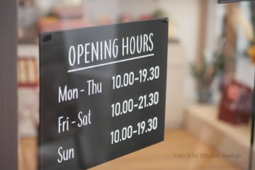 Ein Schild an einem Schaufenster mit den Öffnungszeiten (symbolisch)